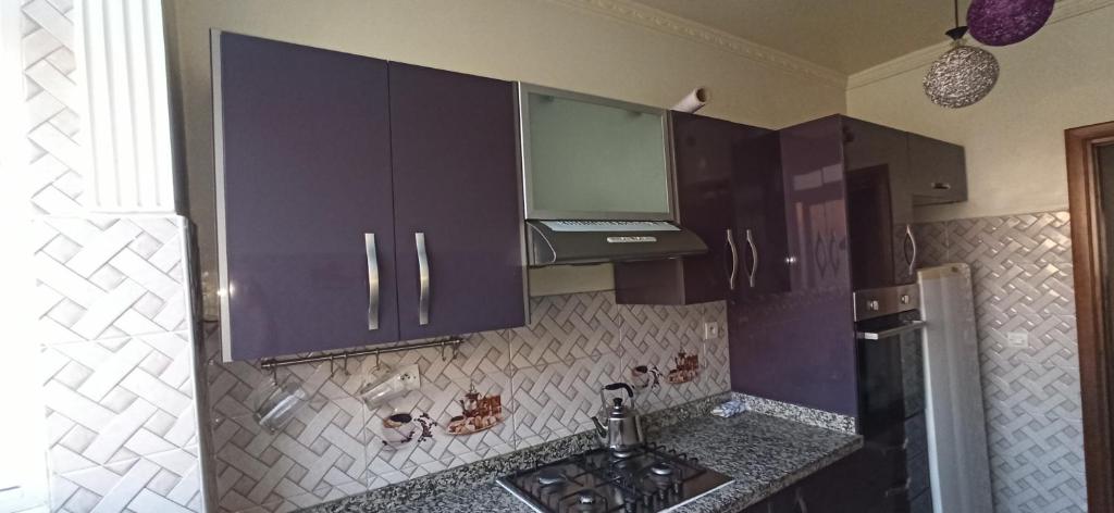 卡萨布兰卡Maison de la famille的厨房配有紫色橱柜和水槽