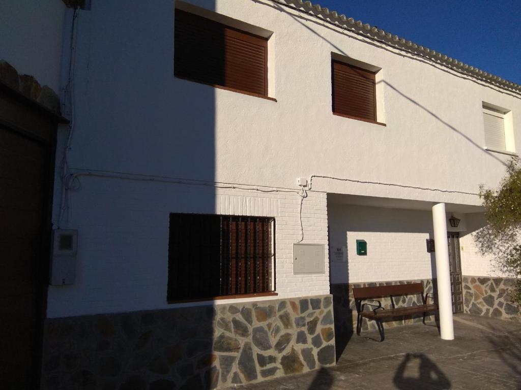 BeiresCasa Rural El Albergue的蓝白色的建筑,前面有长凳
