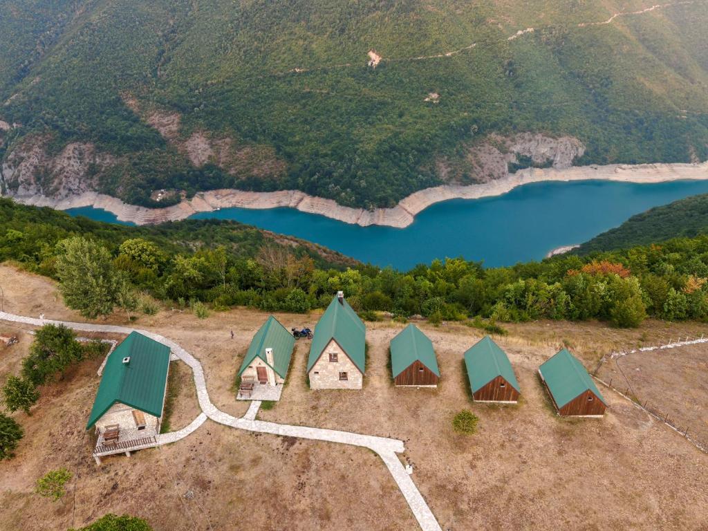 RudiniceEtno selo Izlazak的湖泊旁一组小屋的空中景观