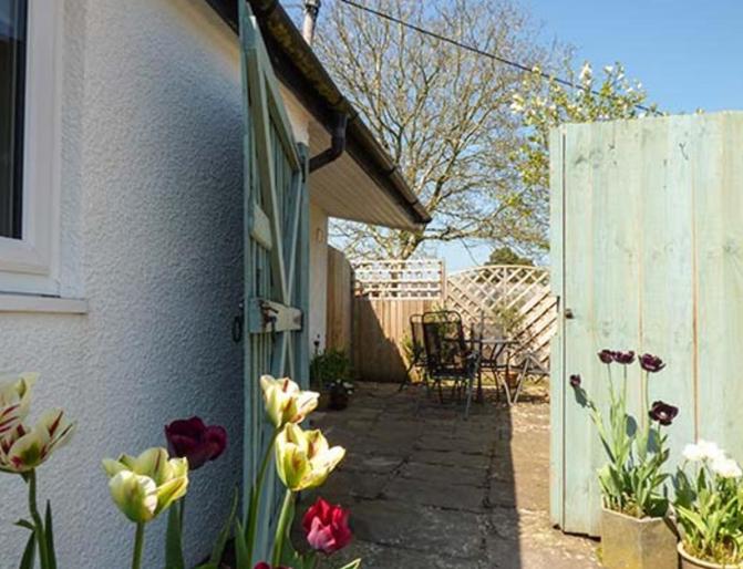 阿伯加文尼Rectory Cottage的鲜花和白色围栏的花园