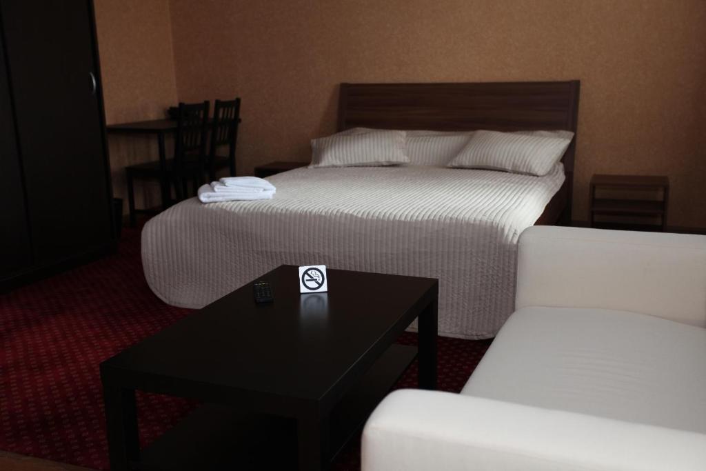 RudnyTroya Hotel的酒店客房带两张床和一张桌子以及椅子。