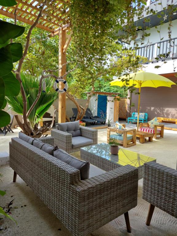 福拉杜岛Palms Retreat的一个带沙发和桌子及遮阳伞的庭院