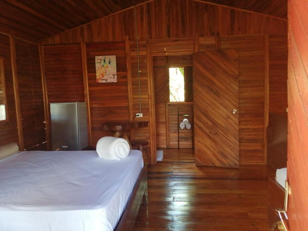 El AchioteCabañas Los Laguitos Rio Celeste的一间卧室设有床铺、木墙和木地板