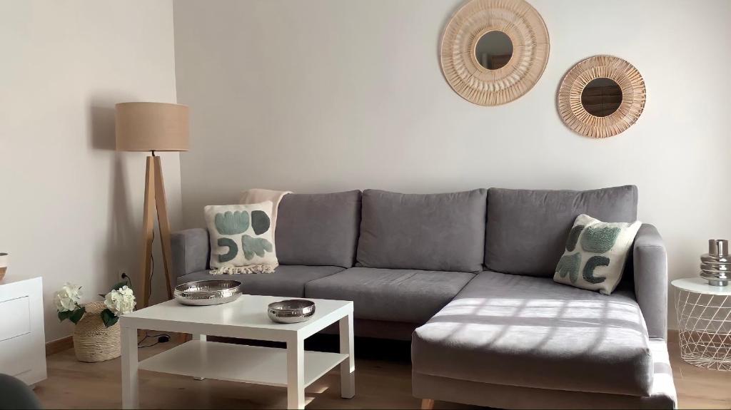 瓦伦西亚Apartamento equipado playa Valencia OnesDeMar的客厅配有灰色的沙发和桌子