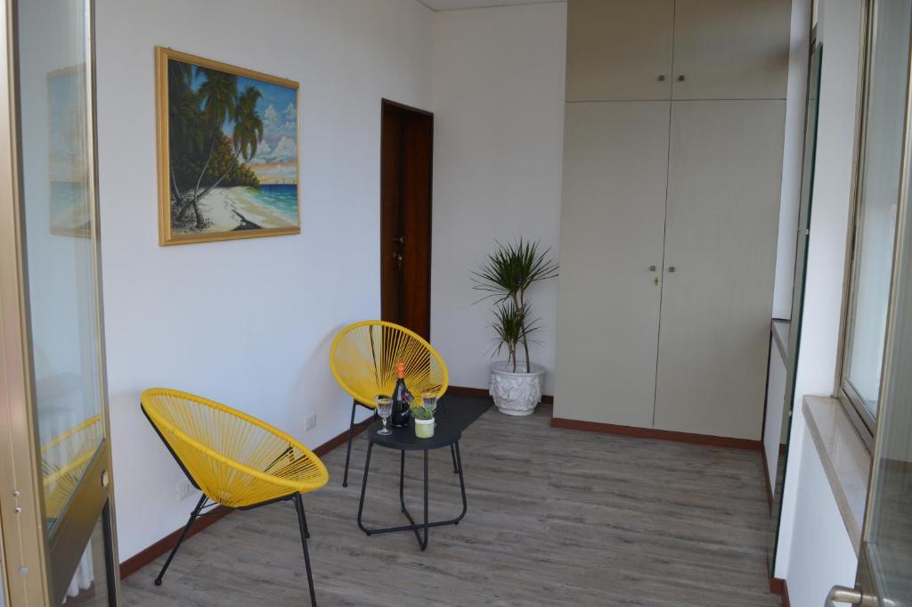 马格拉Noemi Venice Home的一间设有两张黄色椅子和一张桌子的房间
