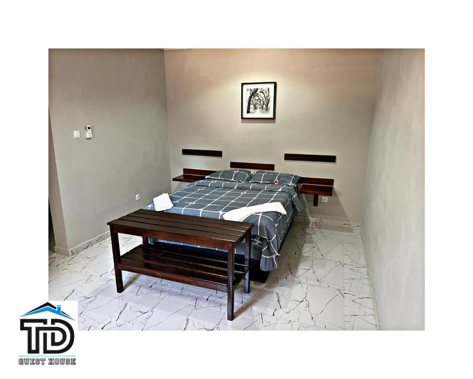 希莫尤TD Guest House 5 Lite的一间卧室配有一张床和一张木桌