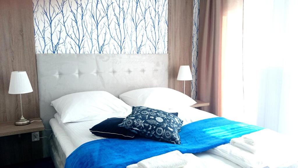 格丁尼亚维拉德鲁嘉4号住宿加早餐旅馆的一张带蓝色毯子和枕头的床