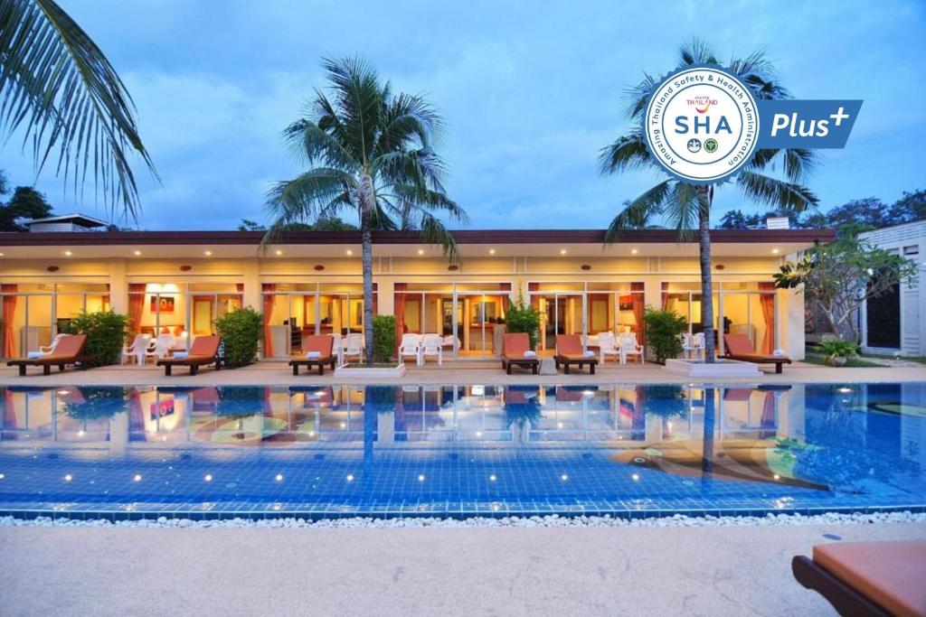 拉威海滩Phuket Sea Resort SHA Extra Plus的大楼前设有游泳池的酒店