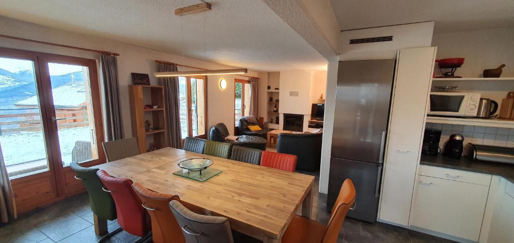 韦松纳Mont Bijou MOUNTAIN & QUIET chalet 10 pers by Alpvision Résidences的厨房以及带木桌和椅子的用餐室。