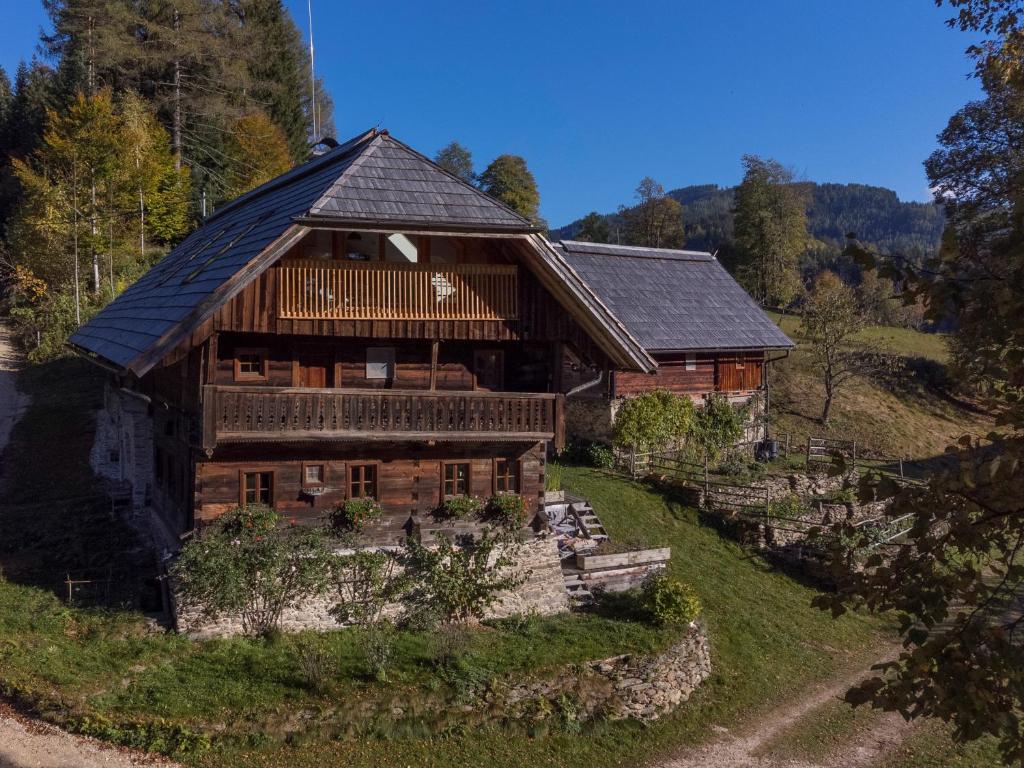 Stanz Im MurztalCharmante Gästewohnung in altem Bauernhaus in alpiner Alleinlage的一座树木繁茂的小山上的木制大房子