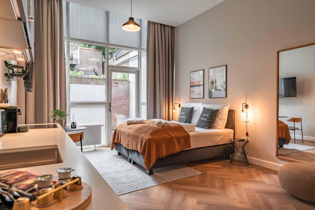 斯海弗宁恩limehome Den Haag Keizerstraat的一间卧室设有一张床和一个大窗户