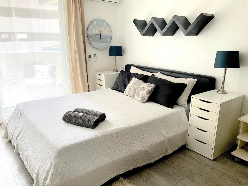 悉尼曼利中心公寓的卧室配有一张带黑色枕头的大型白色床。