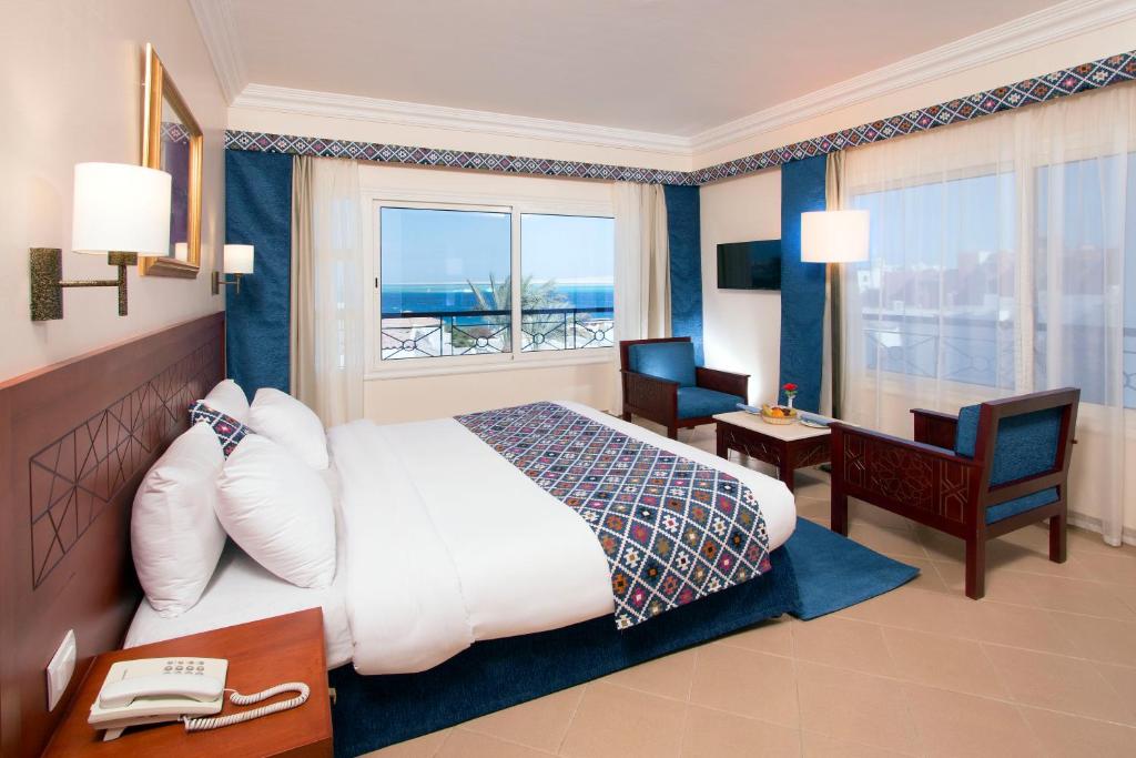 赫尔格达Swiss Wellness Dive Resort的酒店客房设有一张大床和一张书桌。