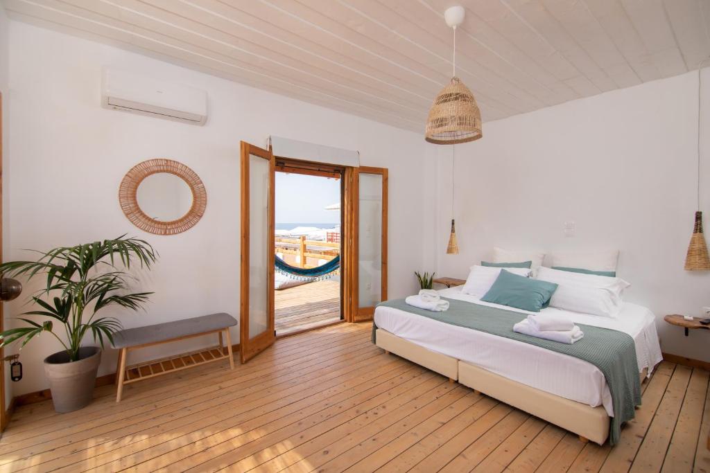 马拉希亚斯Sirens beach houses的一间卧室设有一张床和一个滑动玻璃门