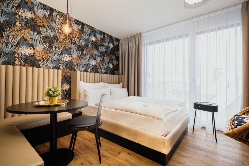 新乌尔姆Rioca Neu-Ulm Posto 5的酒店客房配有一张床铺和一张桌子。