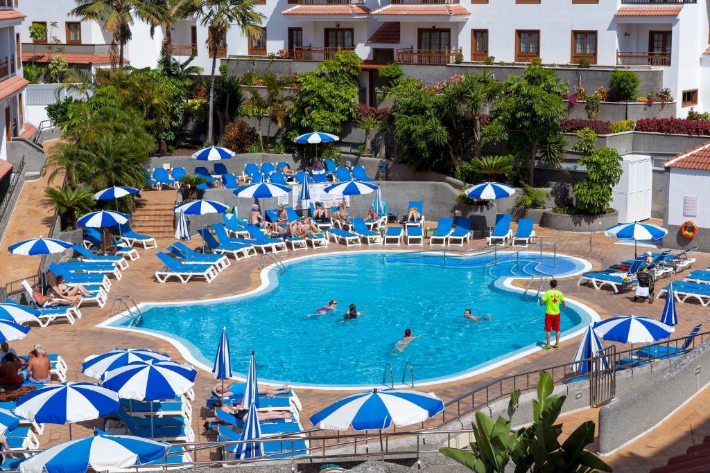 拉克鲁斯卡萨布兰卡公寓的一座拥有蓝白遮阳伞的酒店游泳池