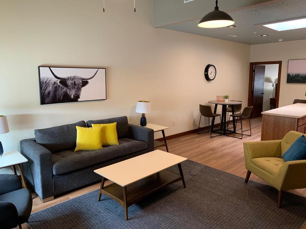 拉皮德城Stylish ground level apartment close to everything的客厅配有沙发和墙上的牛
