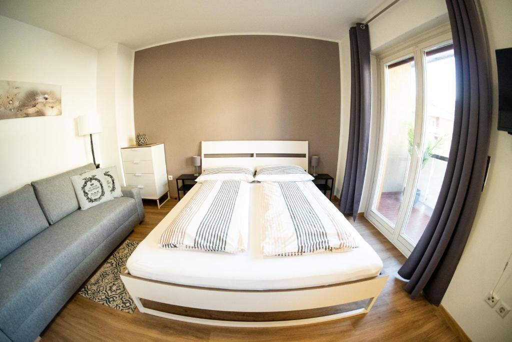 梅拉诺Flow Apartments Piave的一间卧室配有一张大床和一张沙发