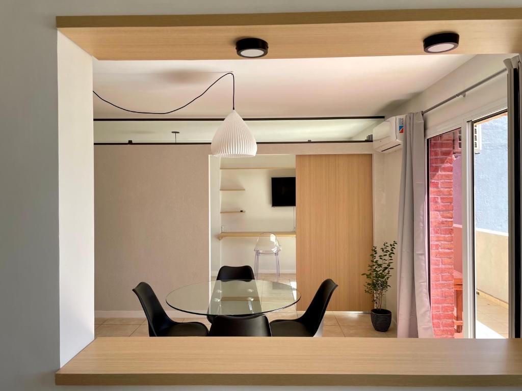 内乌肯Vistas del Sur - 13LV Departamento de dos dormitorios - Categoría Deluxe的一间设有玻璃桌和黑色椅子的用餐室