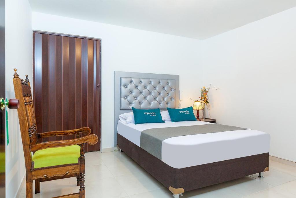 帕斯托Ayenda Colina Real的一间卧室配有一张大床和一把椅子