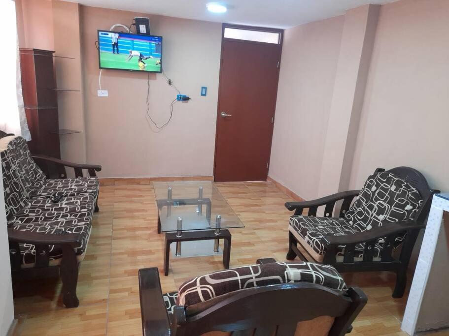 利马Kely3 Cuarto Piso的客厅配有两把椅子、一张桌子和一台电视