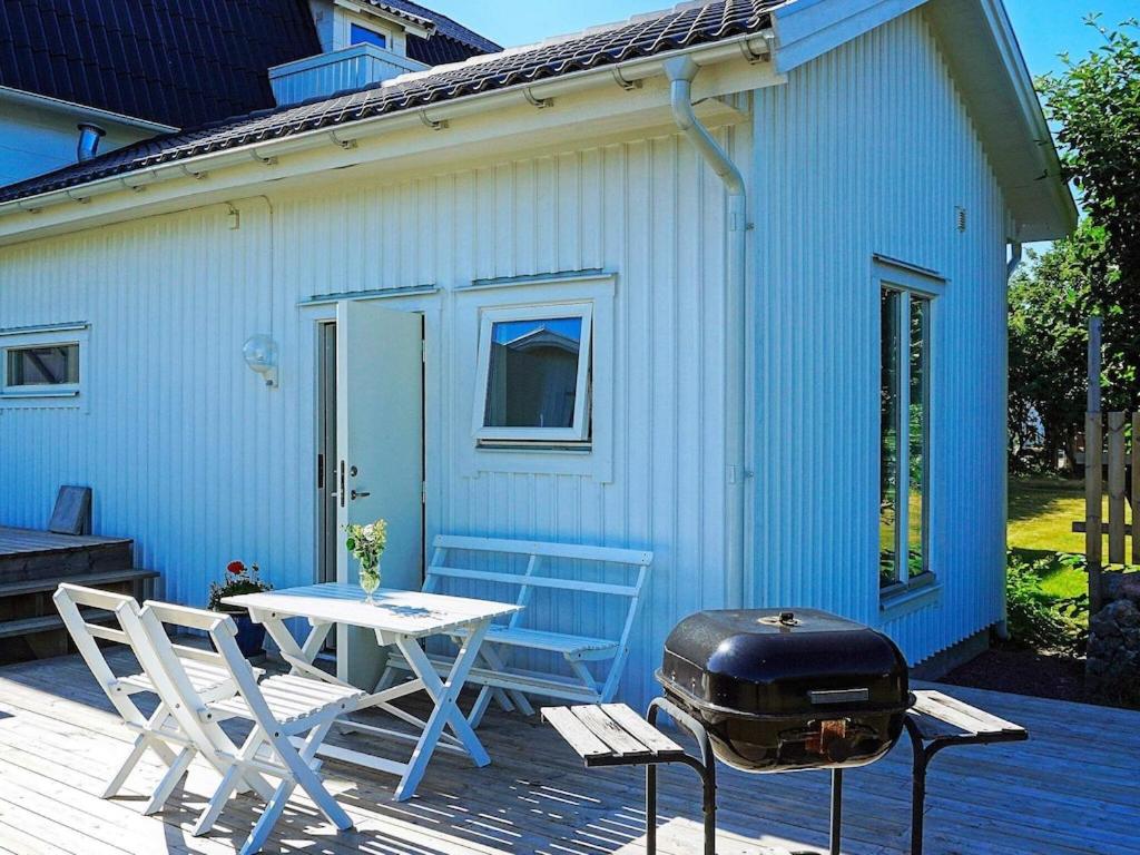 Öckerö4 person holiday home in ker的露台上的烧烤架和桌椅