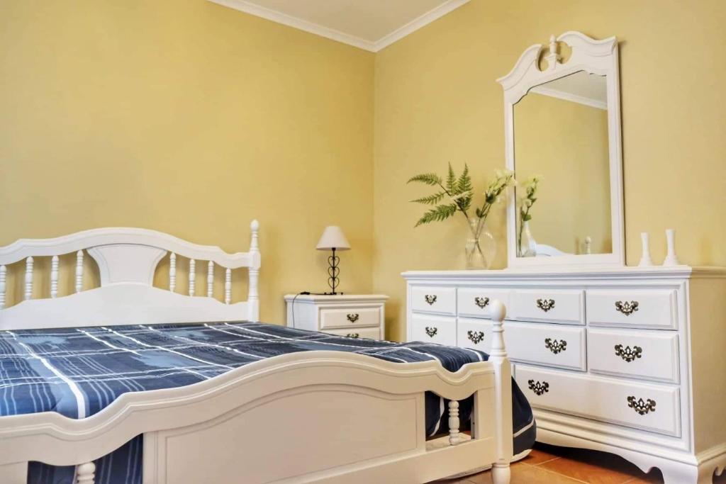 Porto FormosoRibeirinha House的白色卧室配有白色梳妆台和镜子