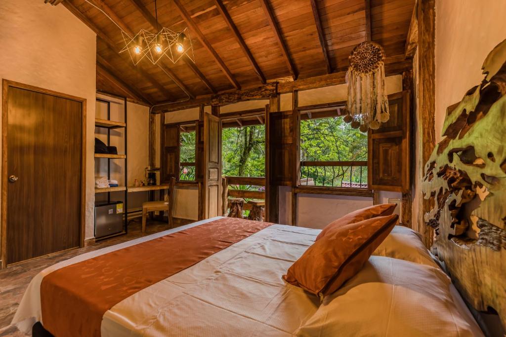 萨兰托Ecohotel Piedemonte的一间带一张大床的卧室,位于带窗户的房间内