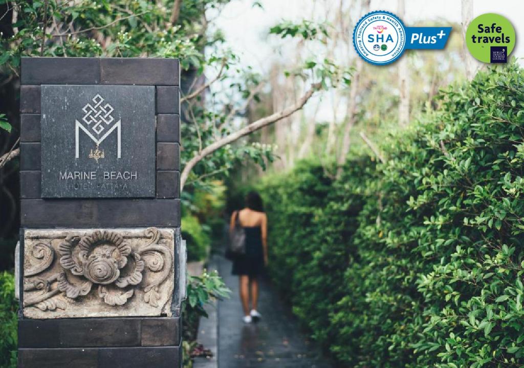 乔木提恩海滩Marine Beach Hotel Pattaya - SHA Plus的走在花园小径上的女人