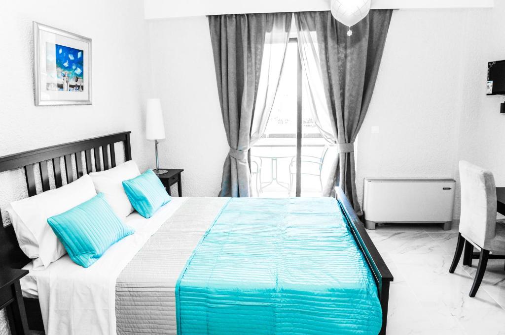 克雷马斯蒂瓦伦蒂诺酒店的一间卧室配有一张带蓝色枕头的床和一扇窗户。