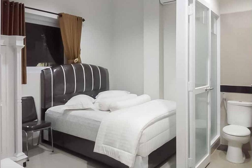 巨港RedDoorz Plus near Palembang Airport 3的一间白色卧室,配有床和卫生间