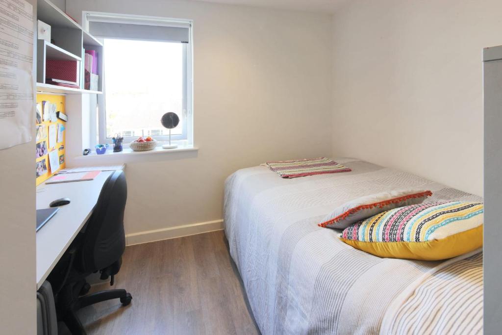 温彻斯特For Students Only Private Bedrooms with Shared Kitchen at Riverside Way in Winchester的一间卧室配有一张带书桌的床和窗户。