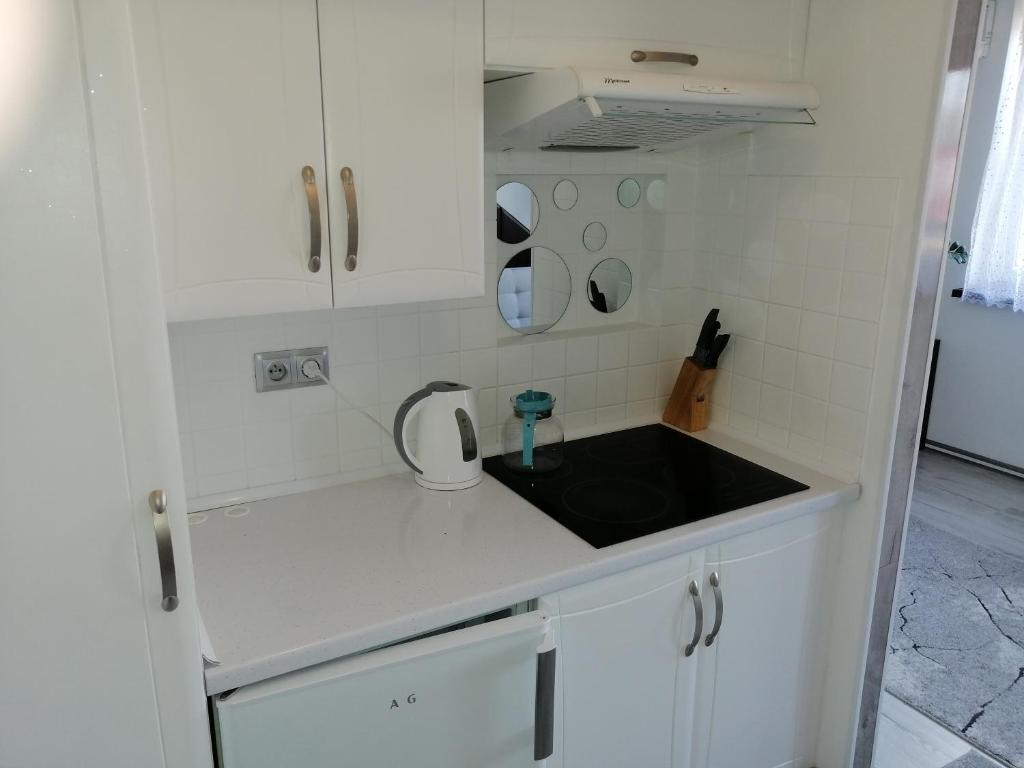 斯卡维纳Apartament Skawina的厨房配有白色橱柜和黑色水槽
