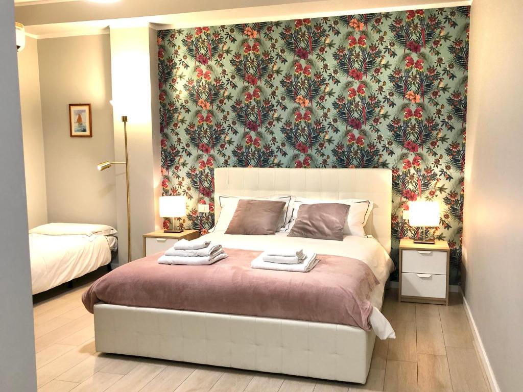 巴里Sunny Beach Bari的一间卧室配有一张带花卉壁纸的大床
