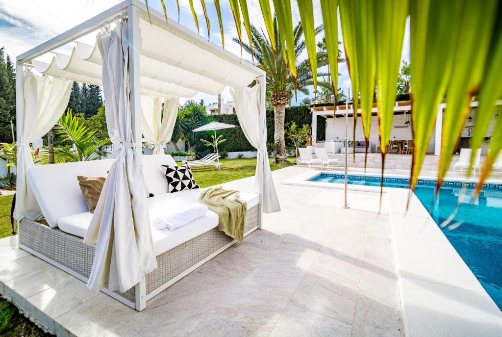 马贝拉VM-Lyxury 4 bedroom villa with private pool的一间卧室设有一张位于游泳池旁的天蓬床