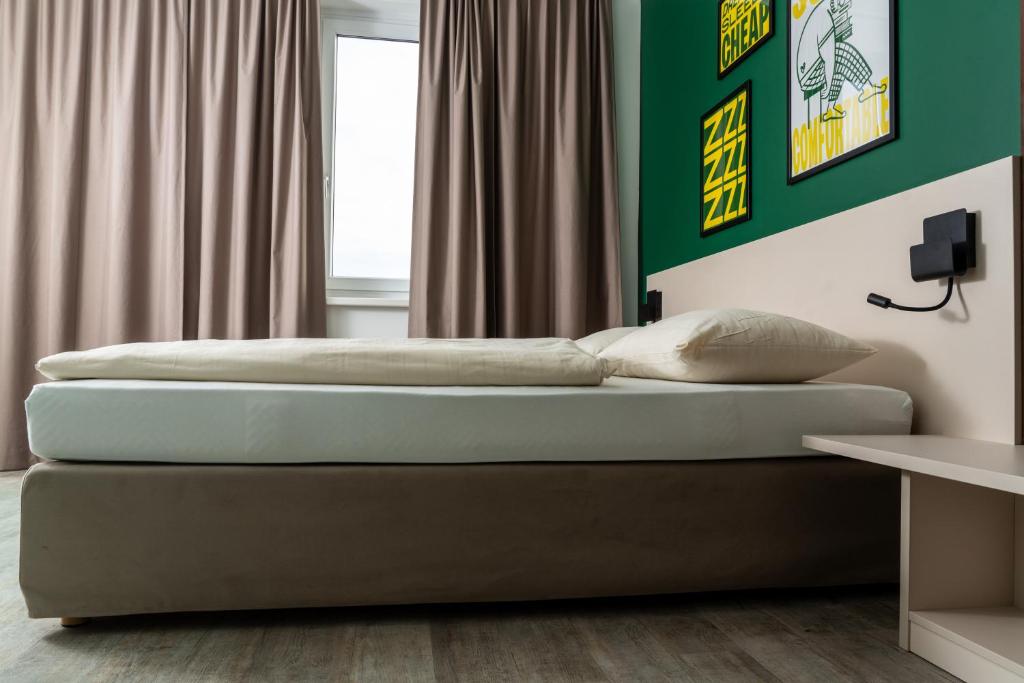 林茨SLEEEP HOTEL Ansfelden的一间卧室设有两张床和绿色的墙壁
