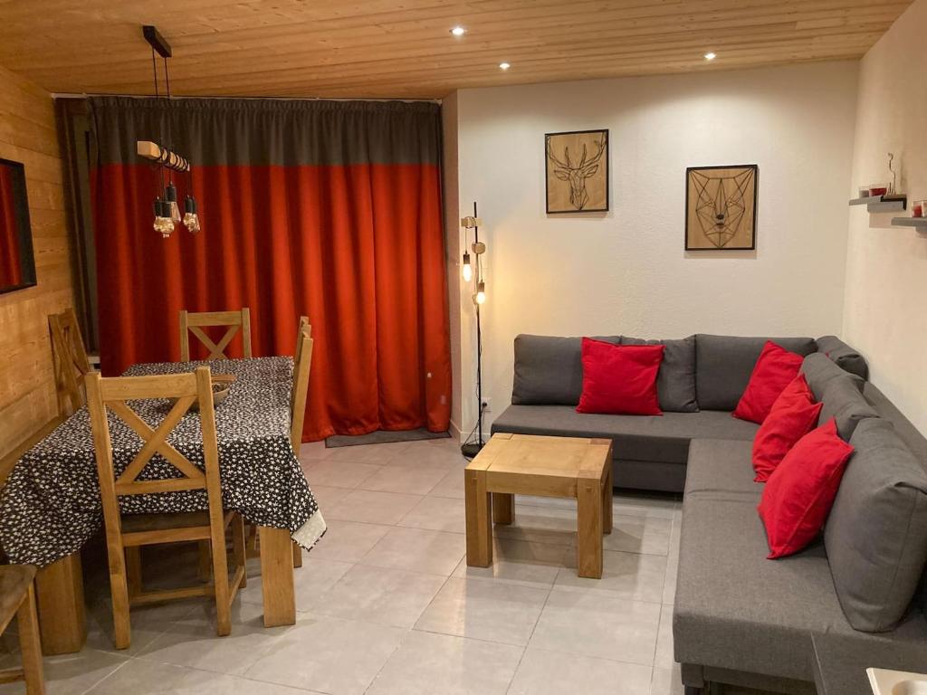 蒂涅Great 8-pax ski-in ski-out apartment in Tignes Val Claret的客厅配有灰色沙发和红色枕头