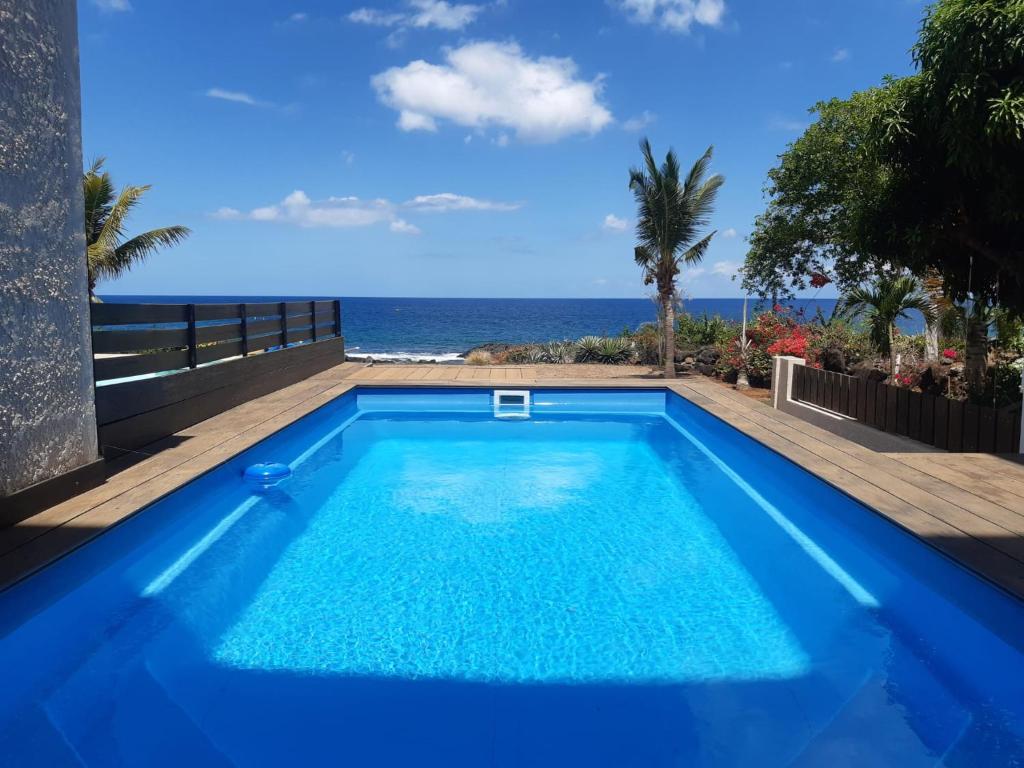 弗利康弗拉克La Falaise Sea Front Villa的蓝色的游泳池,背景是大海