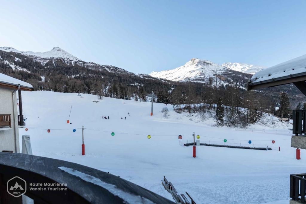 兰斯勒维拉德LES CHENEVERS的一座有雪盖的滑雪场,其背景是群山