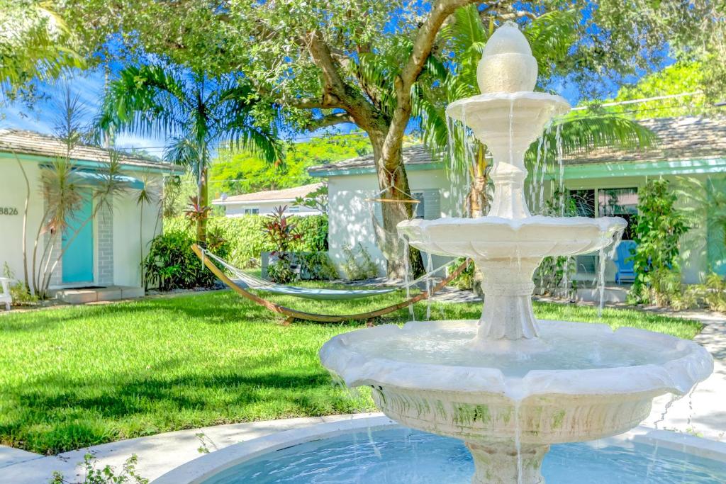 迈阿密Cottages El Portal的庭院里的一个大型白色喷泉,设有吊床