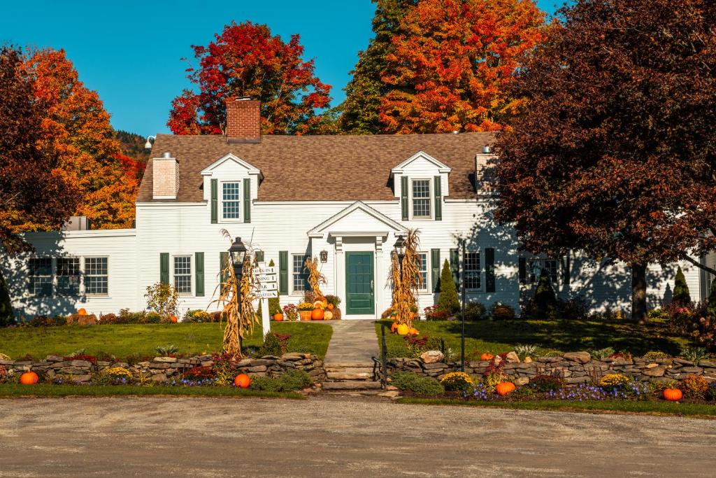 西多佛The Hermitage Inn Vermont的院子里有南瓜的白色房子