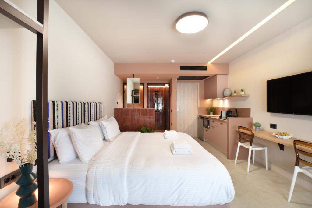 海若克利欧Pavo Art Hotel的卧室配有一张白色大床和一张书桌