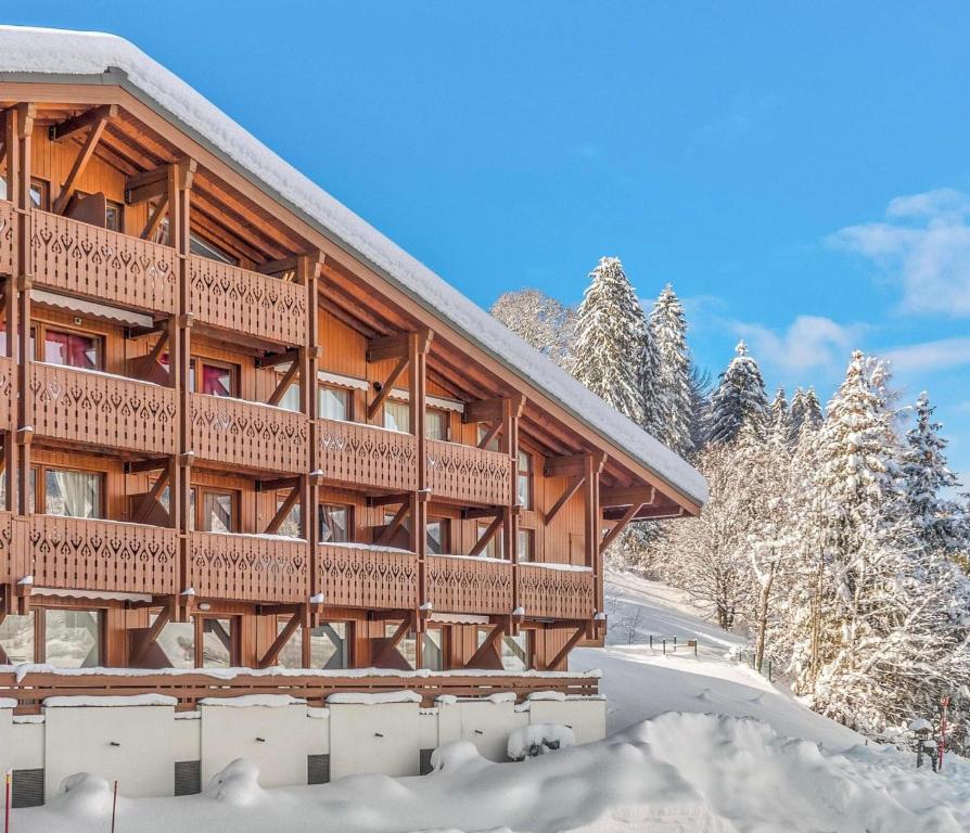 梅杰夫Megève - Appartement 2 chambres - Proche Centre et Pistes - Wifi Netflix - Parking的一座大木结构建筑,地面上积雪