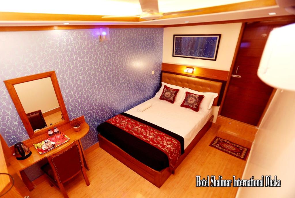 达卡Hotel Shalimar Motijheel - Centre of City的一间小卧室,配有一张床和镜子