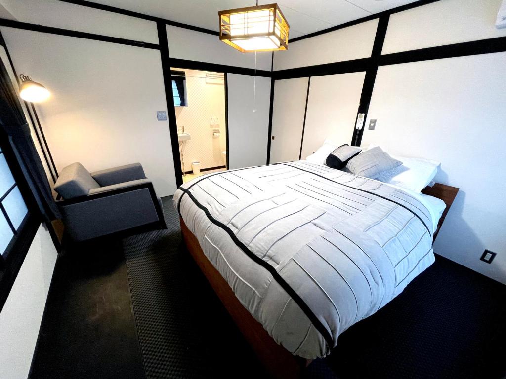 野沢Nozawa Onsen BASECAMP的一间卧室设有一张大床和一个窗户。