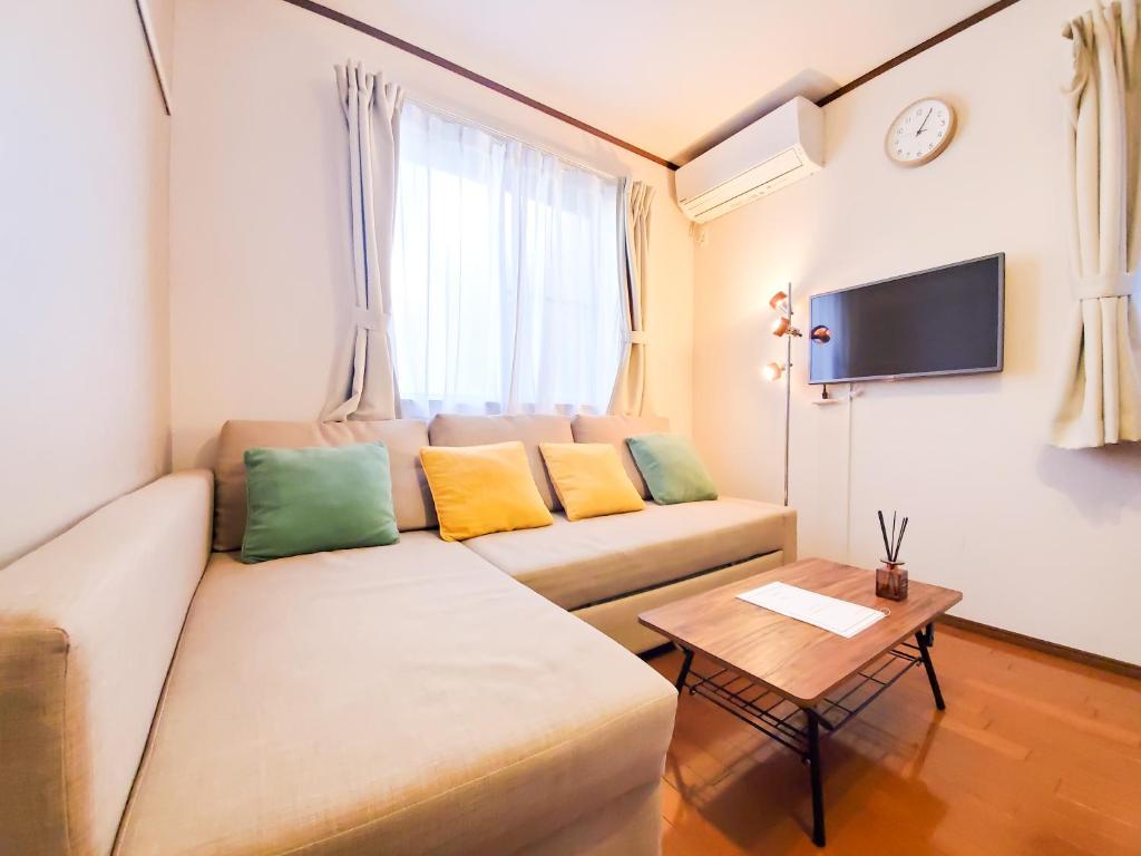 东京nestay suite tokyo shibuya的客厅配有沙发和桌子