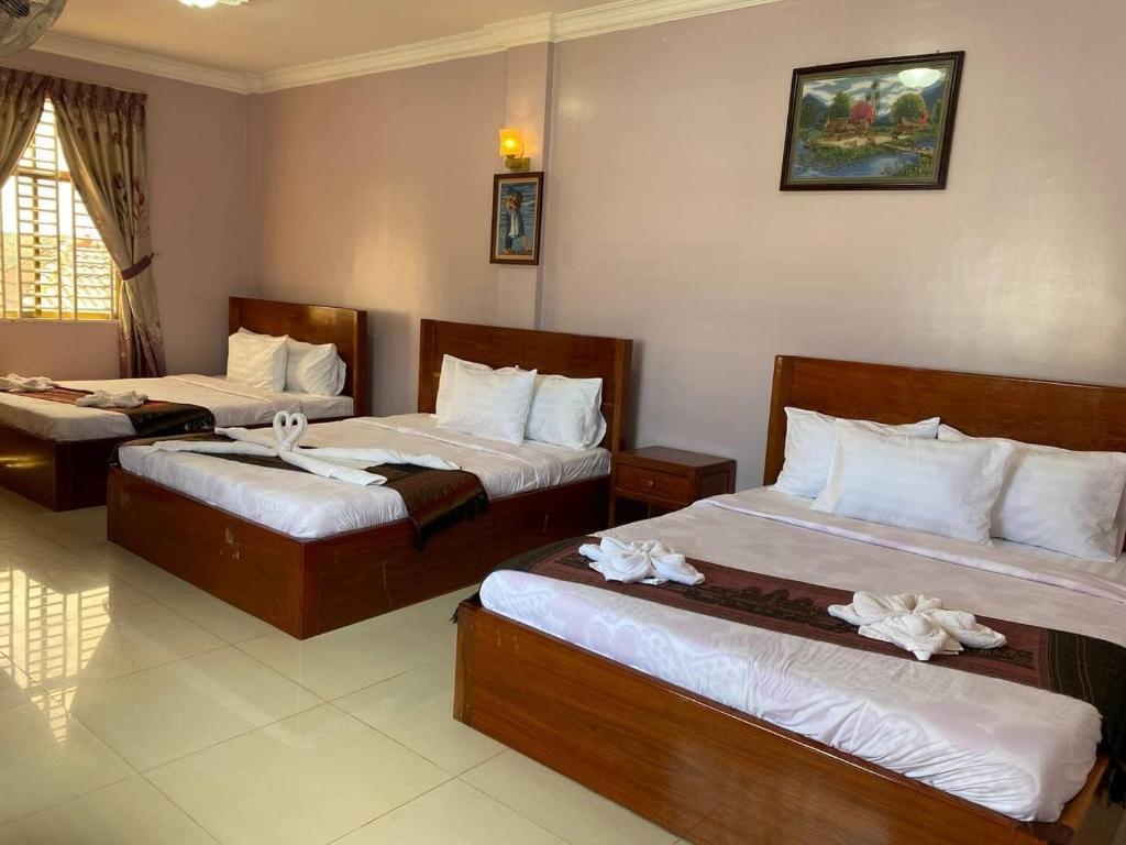 森莫诺隆酪梨宾馆的酒店客房,配有两张带白色床单的床