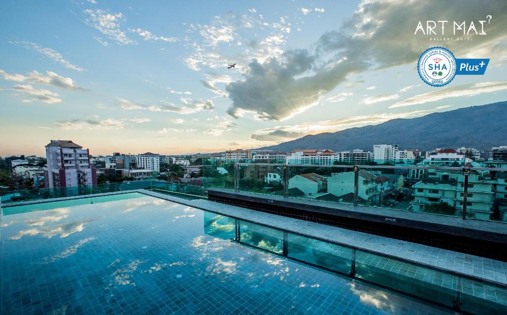 清迈Art Mai Gallery Nimman Hotel Chiang Mai - SHA Plus的一座城市建筑屋顶上的游泳池