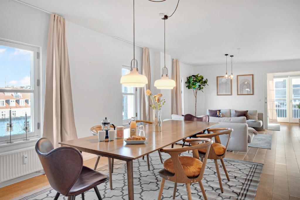 哥本哈根Sanders Haven - Lovely Two-Bedroom Apartment In Historical Copenhagen的用餐室以及带桌椅的起居室。
