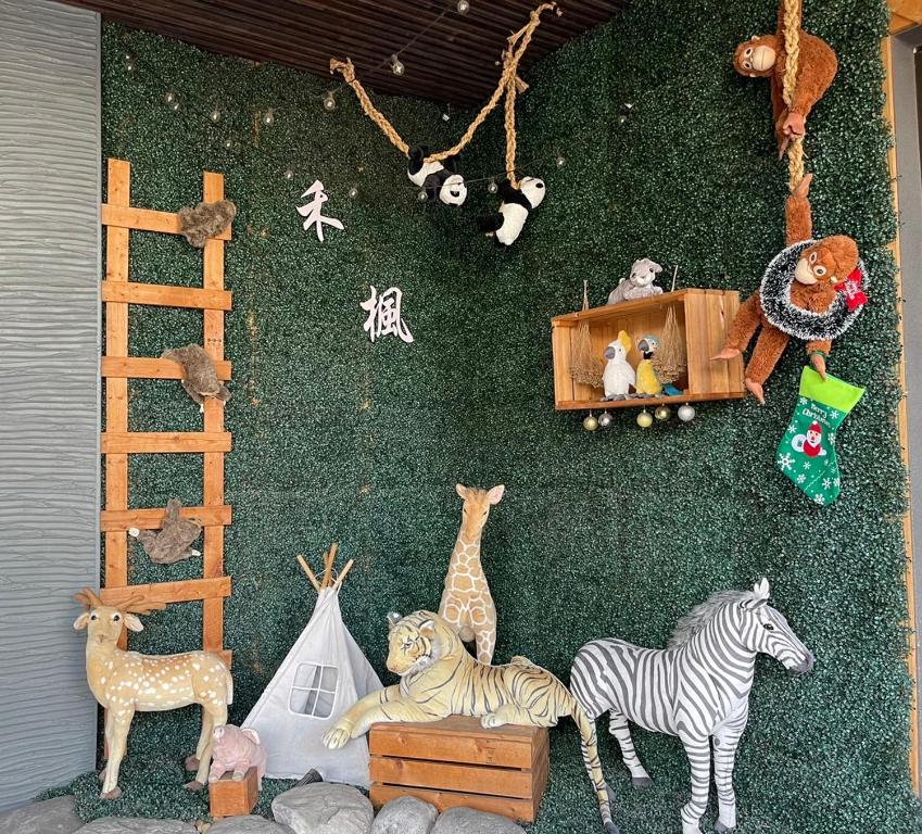 斗六市禾枫SPA汽车旅馆 - 斗六馆的绿色墙上的一群填充物动物